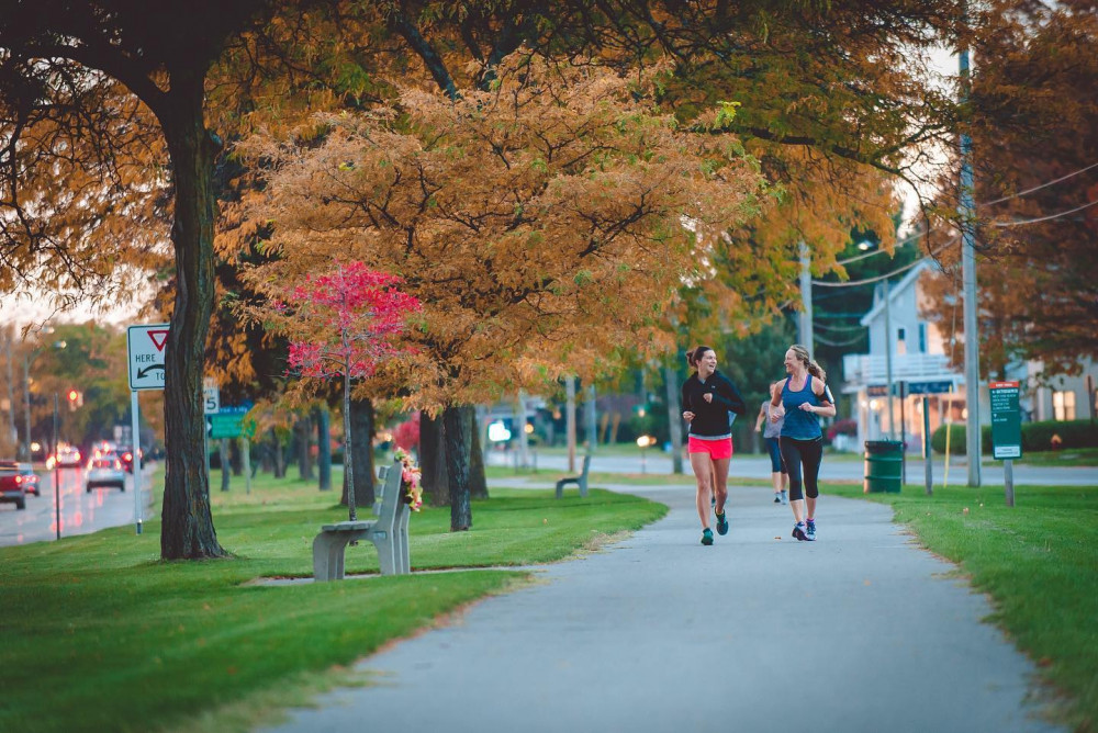 Two runners running on a sidewalk