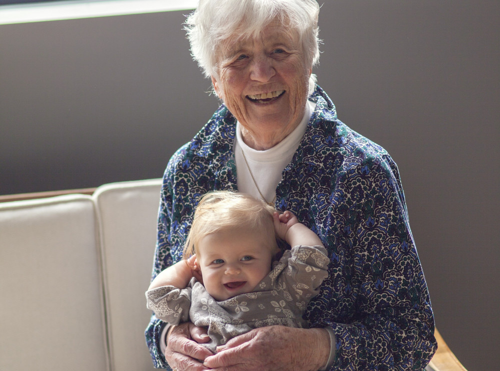 Elderly woman holding a toddler