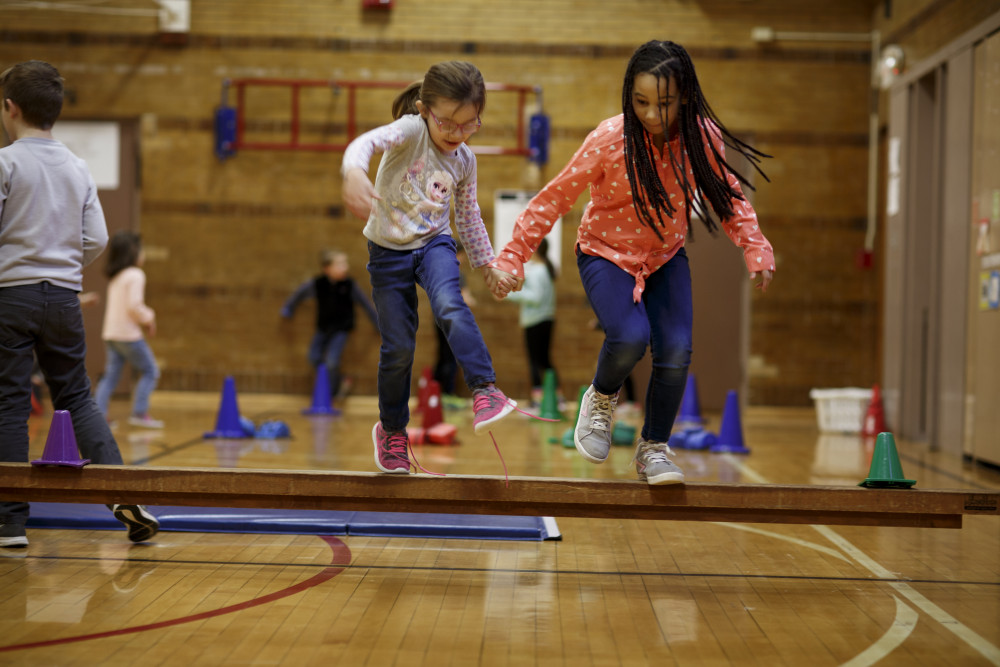 Two girls jumping in a gym