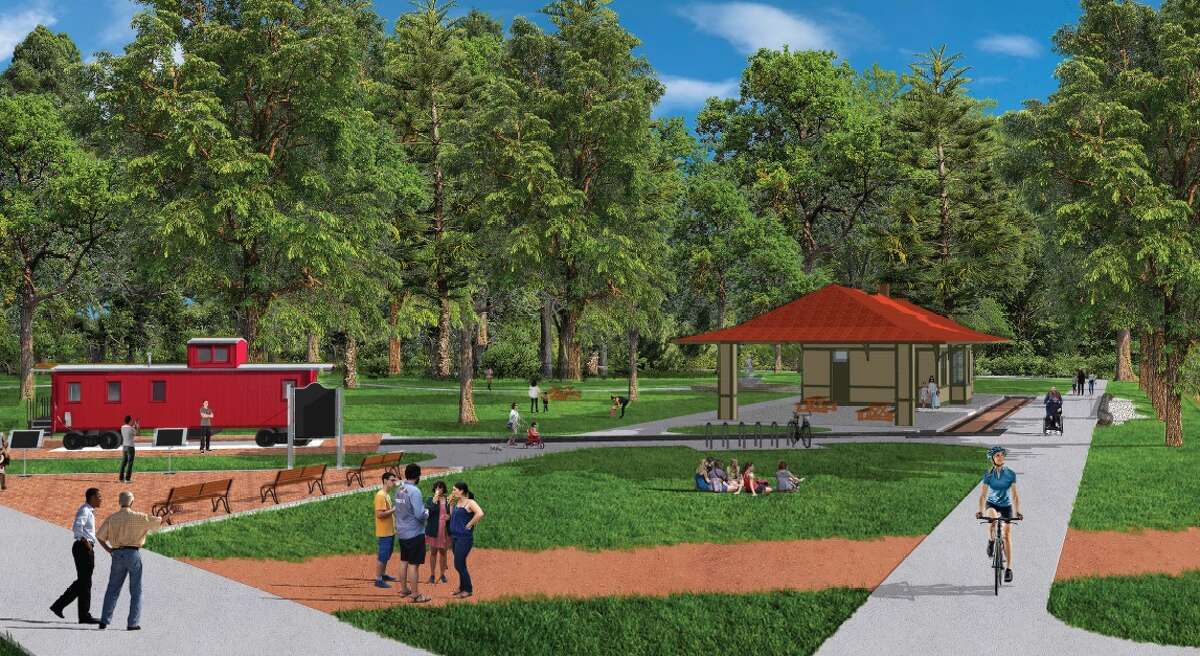 Architectural rendering of a future Thompsonville trailhead park featuring a red train caboose, a red-roofed pavilion with picnic tables, paved walking paths, and people of various ages walking, biking, and sitting in a green, tree-lined space.