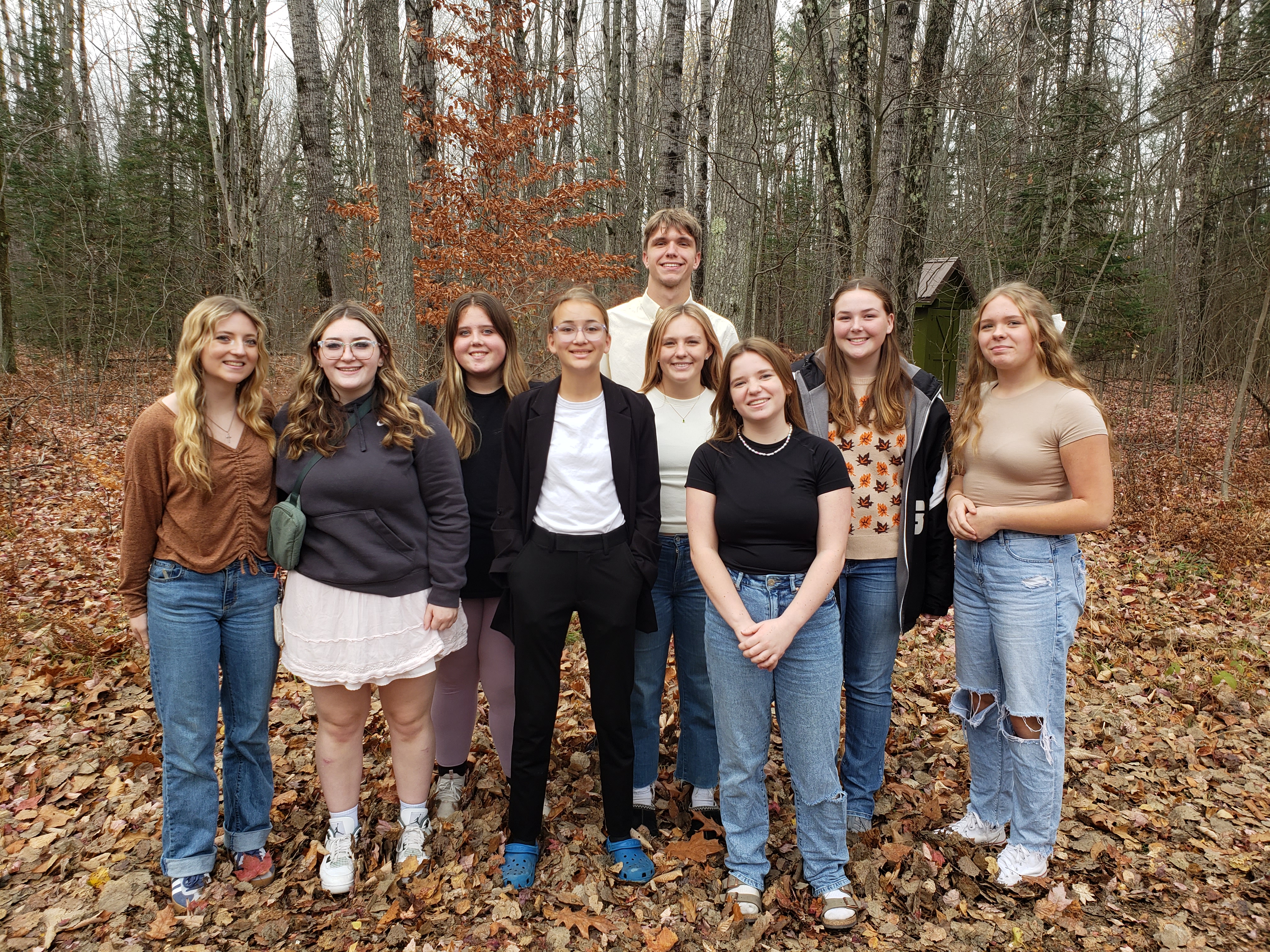 YAC students standing together outside in front of a forested area